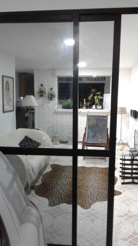 サルバドールにあるCASACOMPART itapuãのベッド1台とガラス窓が備わる客室です。