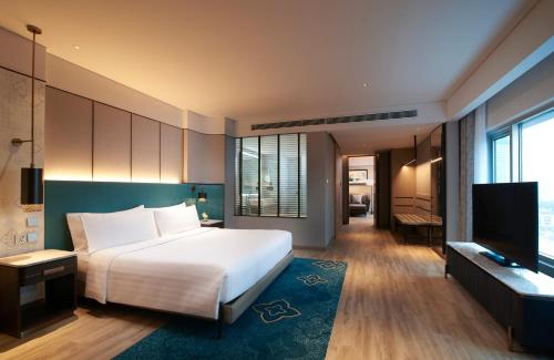 a hotel room with a bed and a television at Amari Watergate Bangkok - SHA Extra Plus Certified in Bangkok