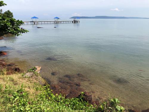 a large body of water with a pier in it at Koh Mak Buri Hut Natural Resort in Ko Mak