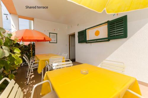 a room with two tables and chairs and an umbrella at Rooms Dejana in Vodice