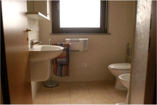 a bathroom with a sink and a toilet and a window at RTA Martin Pescatore in Grosseto