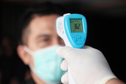 a man in a glove holding up a thermometer at Bien Dong Green Hotel in Ho Chi Minh City