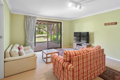 a living room with two couches and a tv at Tranquil Waters in Quindalup
