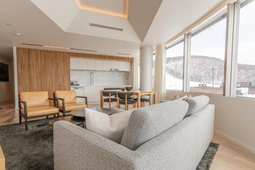 ein Wohnzimmer mit 2 Sofas und einer Küche in der Unterkunft Skye Niseko in Kutchan