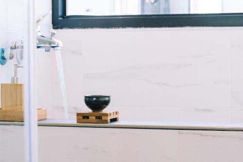 a black bowl sitting on a shelf in a bathroom at 似禾苑民宿 Siheyuan Homestay in Sanxing
