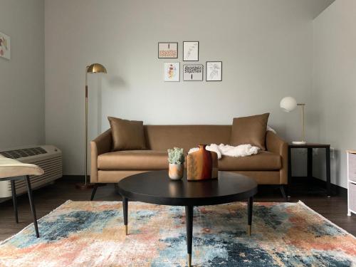 a living room with a couch and a table at Sleepover Iconic Des Moines Apartments in Des Moines