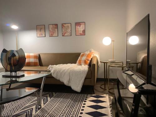 a living room with a couch and a table at Sleepover Iconic Des Moines Apartments in Des Moines