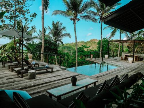 Un resort con piscina, sillas y palmeras. en Villa Kanan, Secluded Jungle Paradise, en Selong Belanak