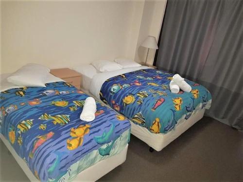 two beds in a hotel room with towels on them at Accommodation Sydney City Centre - 2 Bedroom Apartment with Balcony on Top Floor in Sydney