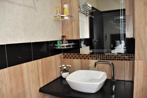 a bathroom with a white sink on a black counter at Annavilla7 Lilongwe Aparthotel in Lilongwe