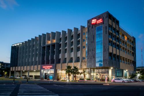 a large building on a street with a parking lot at Co-op City Hotel Seongsan in Seogwipo