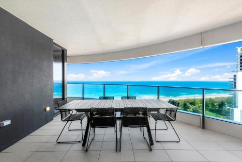 a dining room with a table and chairs and the ocean at Oracle Resort Broadbeach - gclr in Gold Coast
