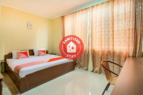 a bedroom with a bed with a red sign on it at Super OYO 3148 Sofia Homestay Syariah in Bogor