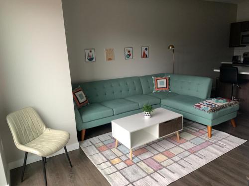 a living room with a couch and a table and a chair at Sleepover Premier Downtown Des Moines Apartments in Des Moines