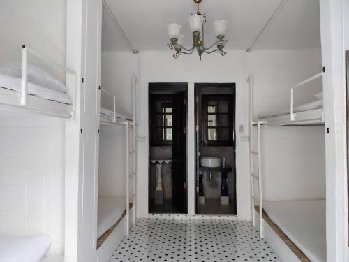 a white room with a hallway with glass doors at At Night in Chumphon