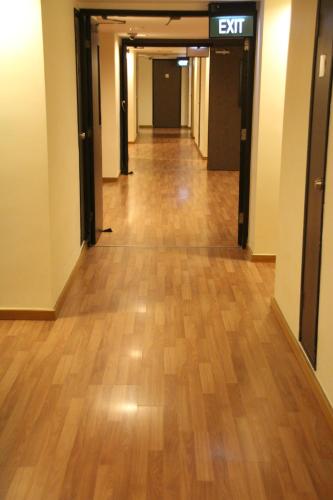 an empty hallway in a building with a hard wood floor at Strand Hotel in Singapore