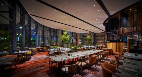 a restaurant with tables and chairs in a building at EQ Kuala Lumpur in Kuala Lumpur