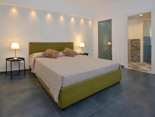 een slaapkamer met een groot bed met 2 lampen bij B&B Dimora Tomasi in Palermo