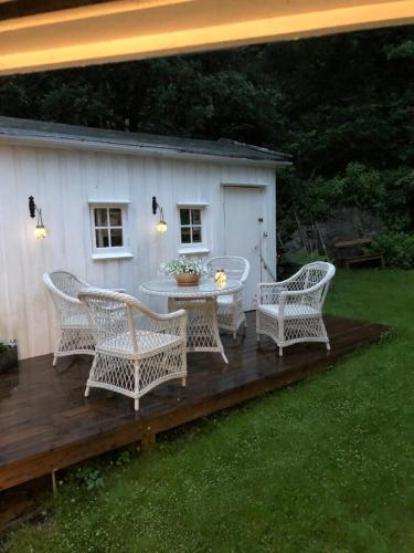 a patio with wicker chairs and a table on a deck at Aid og Svein’ s sentrumsnære panorama hjem in Kristiansand