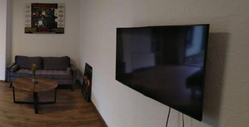 a flat screen tv hanging on a wall in a living room at Kleine Ferienwohnung, Einzimmeraparment in Altenkirchen in Almersbach