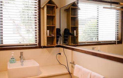 a bathroom with a sink and two windows at Apollo Stay in Apollo Bay