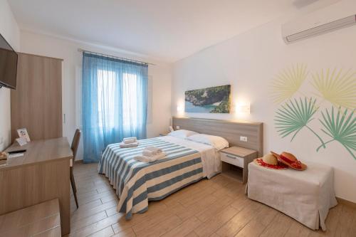 um quarto de hotel com uma cama e uma secretária e um quarto em La Nicchia em San Vito lo Capo