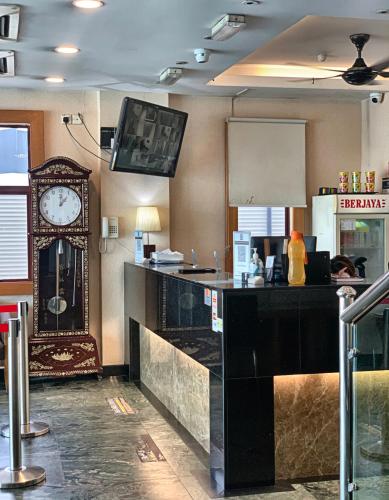a bar in a restaurant with a clock on the wall at Kepong Hotel in Kuala Lumpur