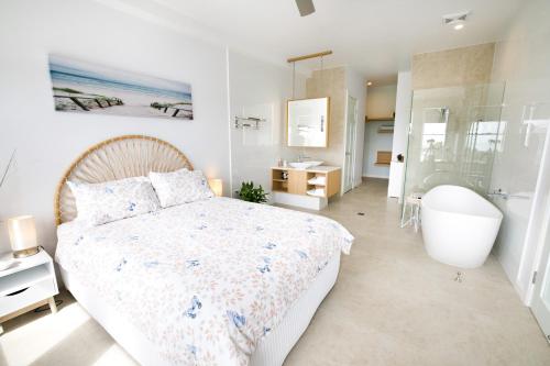 1 dormitorio con 1 cama y baño con bañera en Caba Break Holiday Apartments en Cabarita Beach
