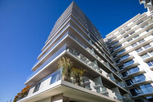 a tall white apartment building with plants on the balconies at Apartament Prestige & Sea Balticus A4 in Międzyzdroje
