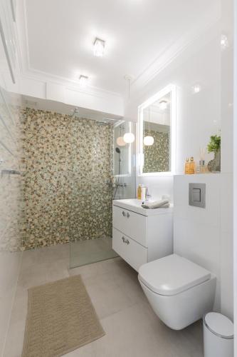 a white bathroom with a toilet and a shower at Apartament Prestige & Sea Balticus A4 in Międzyzdroje