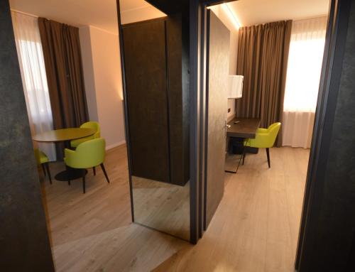 a mirror in a room with a table and chairs at Hotel Friuli in Udine