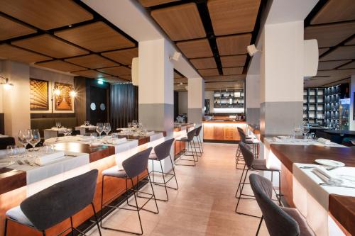 a restaurant with tables and chairs and a bar at Novotel Parma Centro in Parma