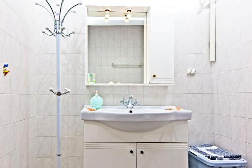a white bathroom with a sink and a mirror at Sifnos Residence in Platis Gialos