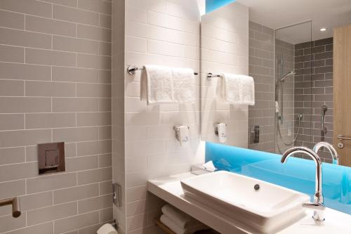uma casa de banho branca com um lavatório e um chuveiro em Holiday Inn Express - Kaiserslautern, an IHG Hotel em Kaiserslautern