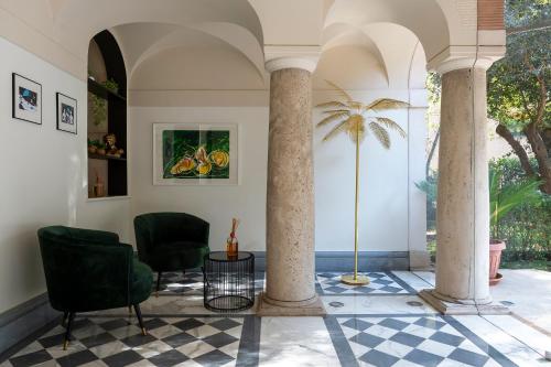 a lobby with two chairs and a palm tree at Hotel Principe Torlonia in Rome