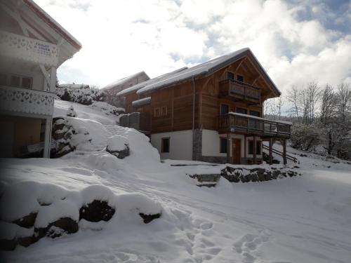 a house covered in snow next to a building at Les Adrets in Gérardmer