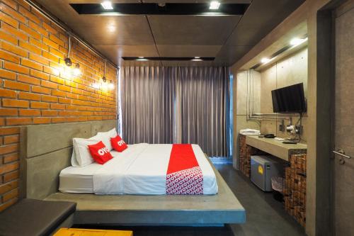 Ban KoにあるOYO 75368 Demadre Resortのレンガの壁、ベッド付きのベッドルーム1室