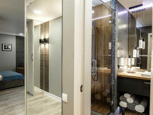 y baño con ducha acristalada y lavamanos. en Apartament on Sovetskaya 80 en Bobruisk