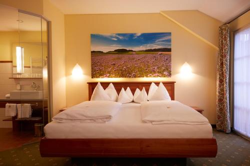 a bedroom with a bed with a painting on the wall at Hotel & Restaurant Stern in Gmünd