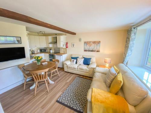Primrose Cottage في مالتون: غرفة معيشة مع أريكة وطاولة