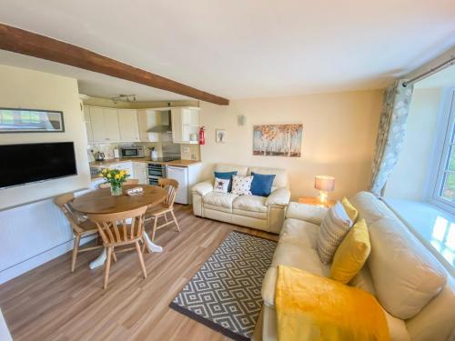 a living room with a couch and a table at Primrose Cottage in Malton