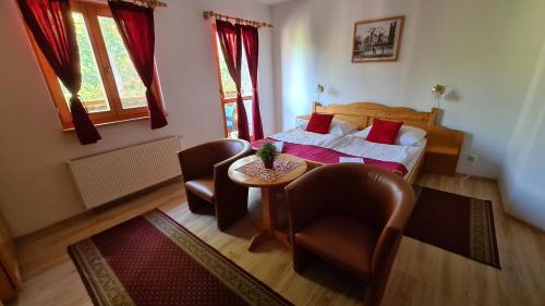 Schlafzimmer mit einem Bett, einem Tisch und Stühlen in der Unterkunft Hotel Koliba in Senec