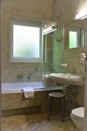 a bathroom with a tub and a sink and a window at Ferienhaus Wetterstein in Grainau