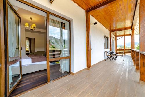 um quarto com uma varanda com uma cama e janelas em Yael Luxury Apartments 3 em Buşteni