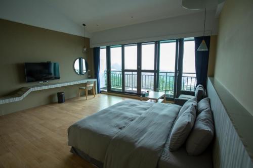 sypialnia z dużym łóżkiem i balkonem w obiekcie 茶緣觀舍民宿 w mieście Fanlu