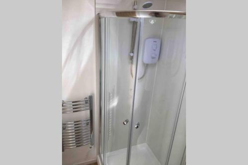 a shower in a bathroom with a glass door at Ty Haf in Milford Haven