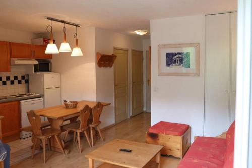 une cuisine et une salle à manger avec une table et des chaises dans l'établissement Le Cocon d'Aran, à Luchon