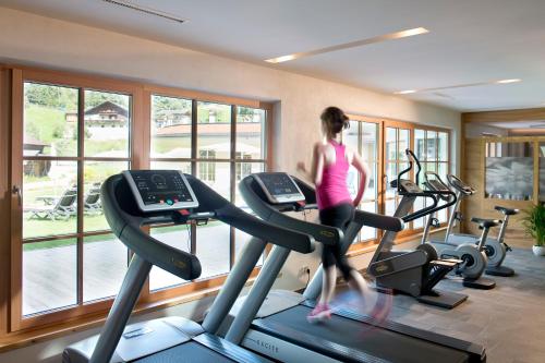 a woman running on a treadmill in a gym at Living & Spa Vitalhotel Edelweiss in Neustift im Stubaital