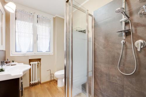 uma casa de banho com um chuveiro, um WC e um lavatório. em Nel cuore del Centro Storico Cozy Apartment em Bolonha