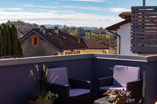 a balcony with purple chairs and a view at B&B Giardini dell'Ardo in Belluno